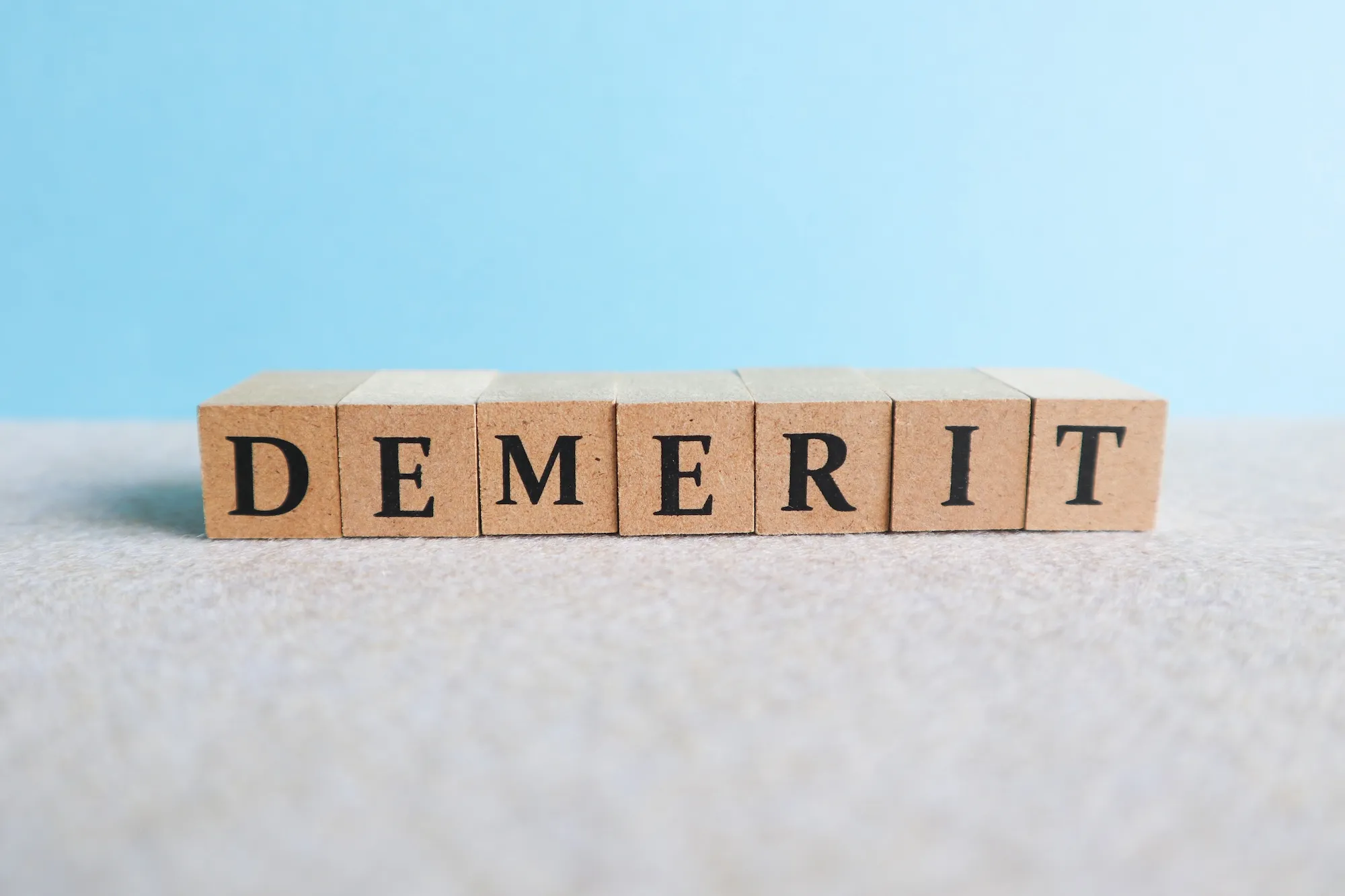 「DEMERIT」と書かれた木のブロック